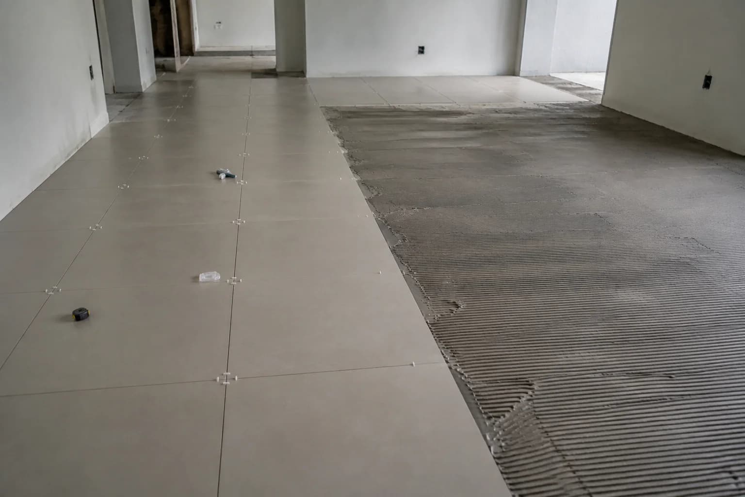 Piso de porcelanato parcialmente assentado com cimento-cola aparente